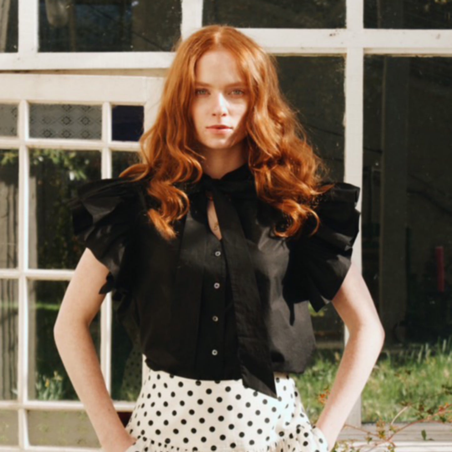 Mia frill blouse in plain black cotton lawn with frill sleeves and tie neck.