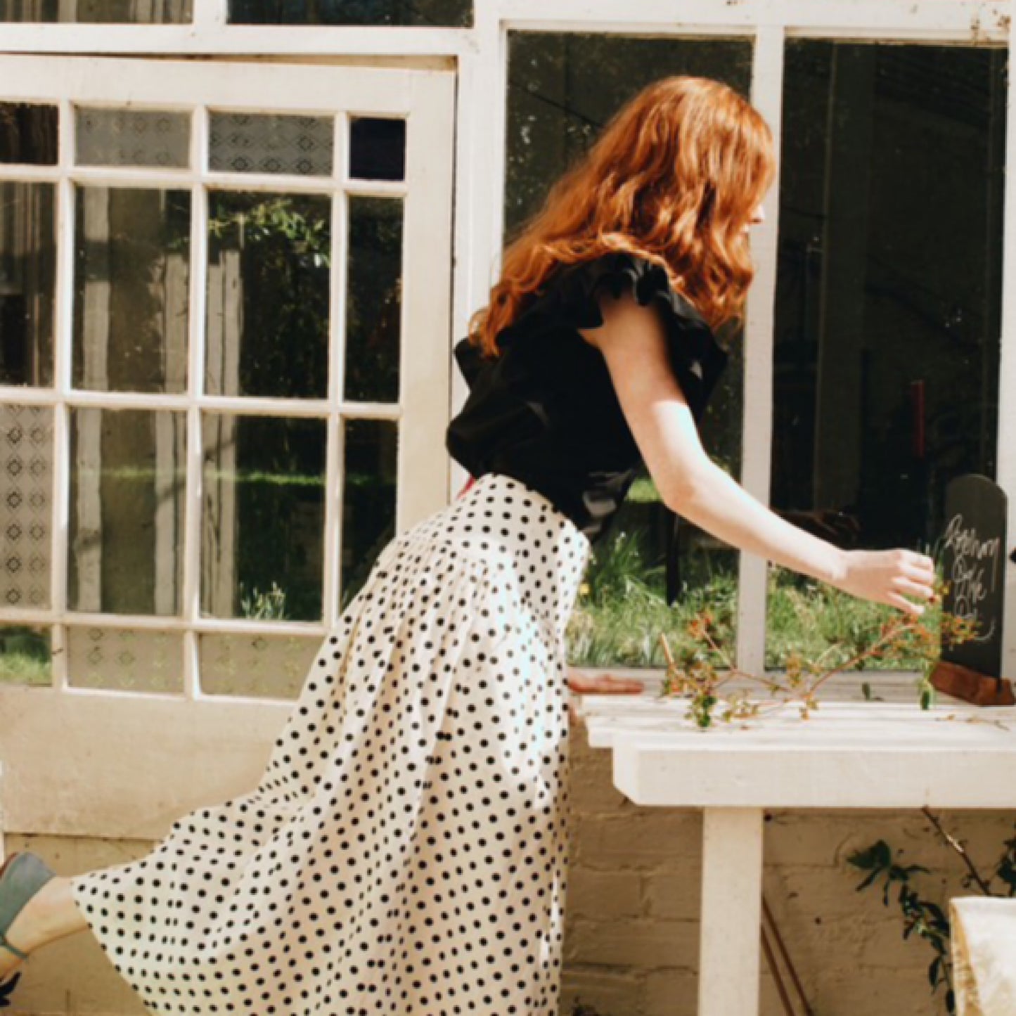 Mia frill blouse in plain black cotton lawn with frill sleeves and tie neck.