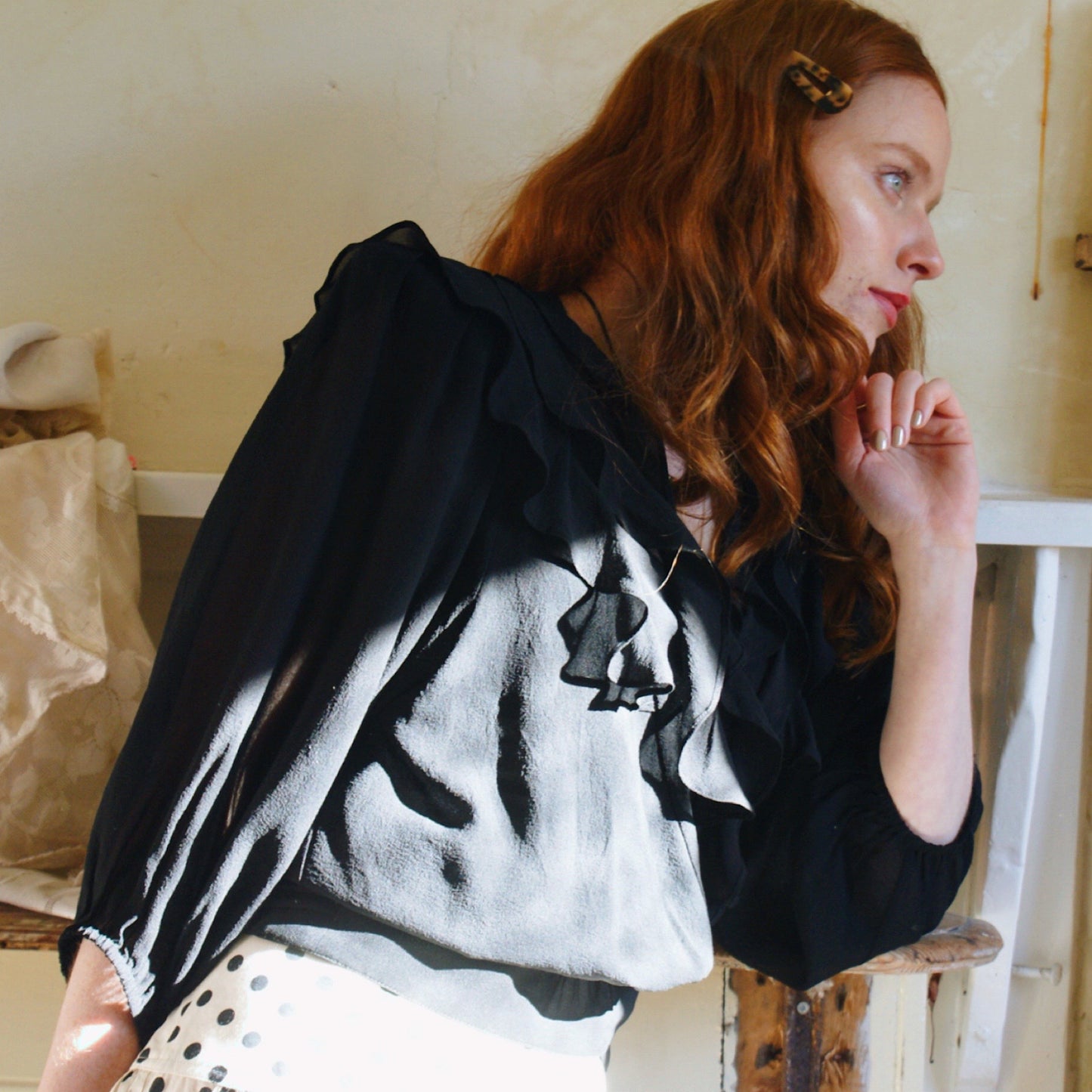 Phoebe blouse in black viscose georgette with wrap front and ruffles.