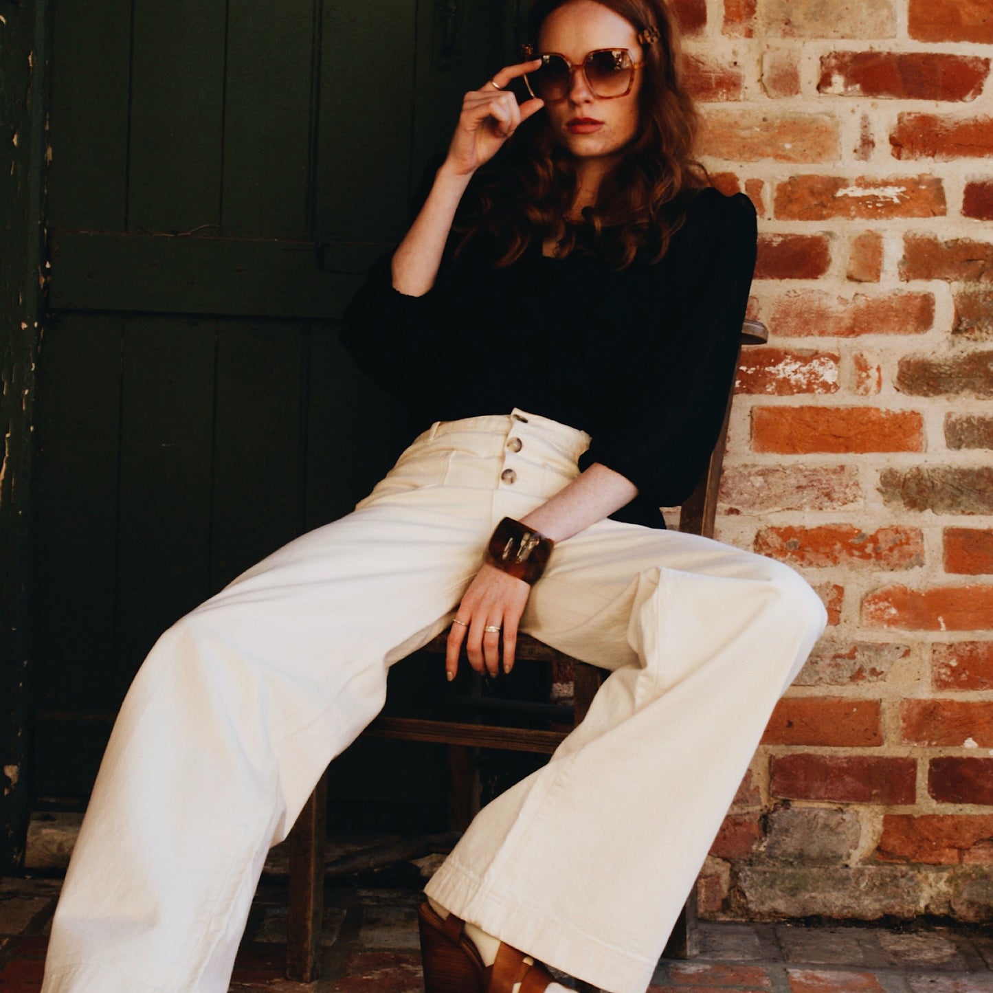 Phoebe blouse in black viscose georgette with wrap front and ruffles.