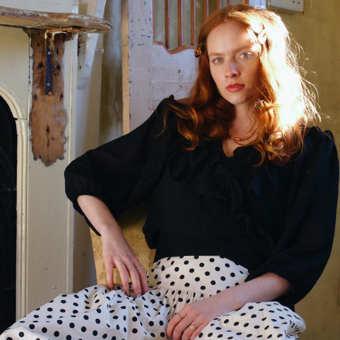 Phoebe blouse in black viscose georgette with wrap front and ruffles.