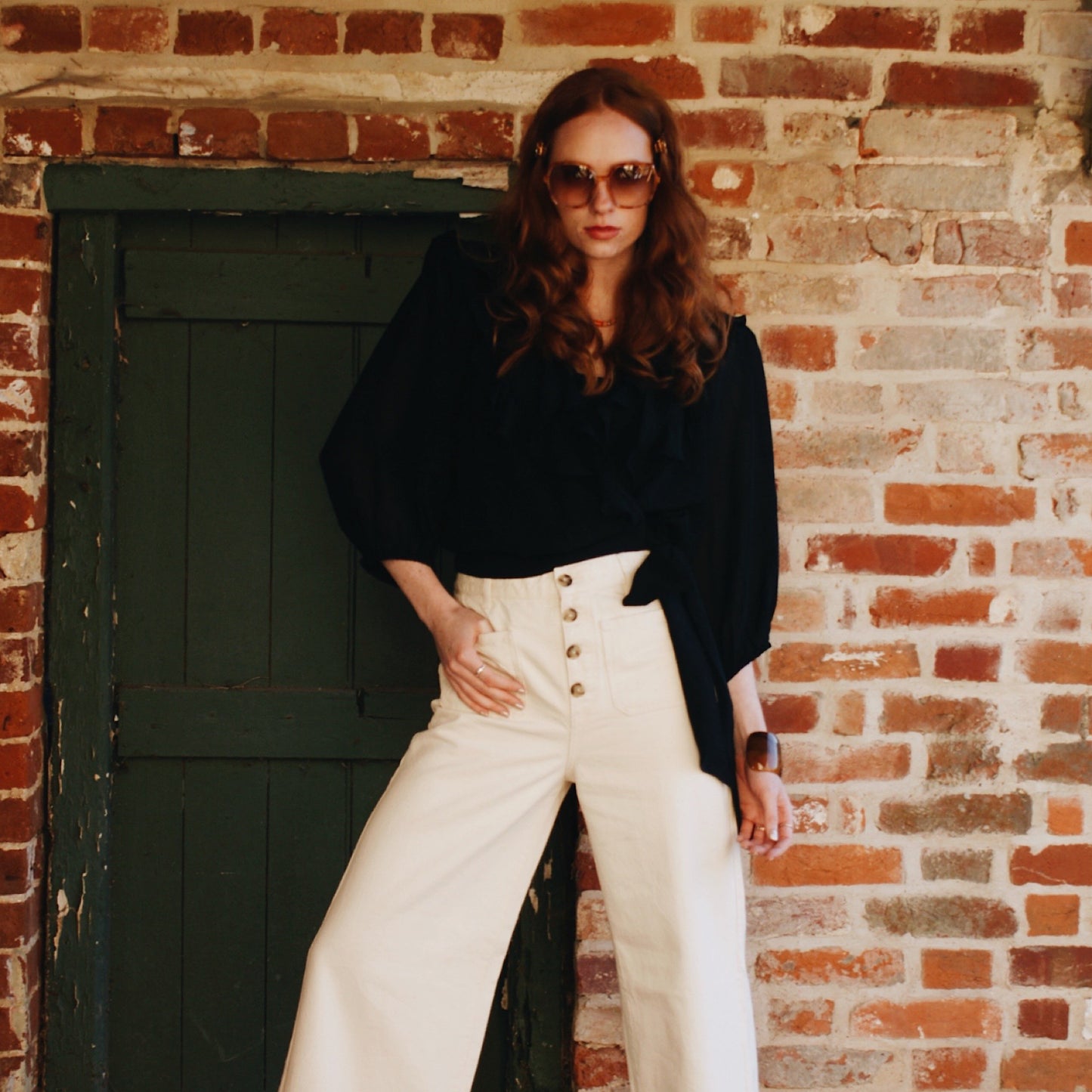 Phoebe blouse in black viscose georgette with wrap front and ruffles.