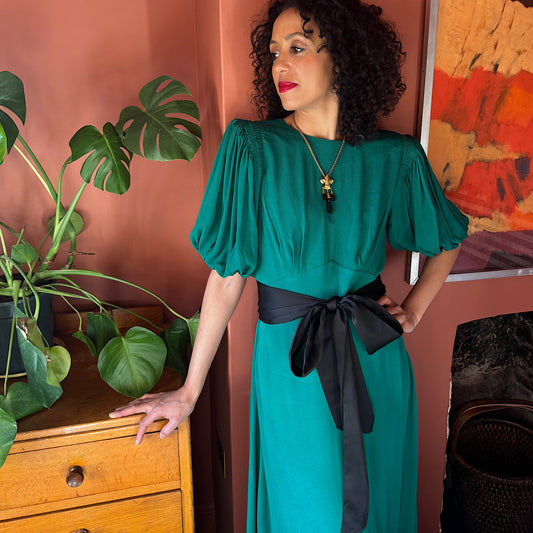 Clemence dress in jewel green viscose crepe with contrast black satin belt.